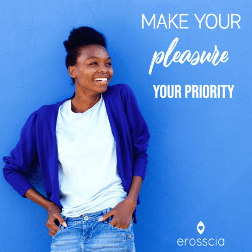 Eine glückliche Frau mit blauem Hintergrund lächelt, während sie ihr Vergnügen zu ihrer Priorität macht. Erosscia ist Vergnügen neu gedacht