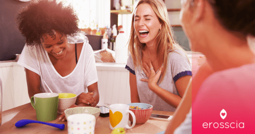 Studentinnen sitzen an ihrem Frühstückstisch und lachen über Sex